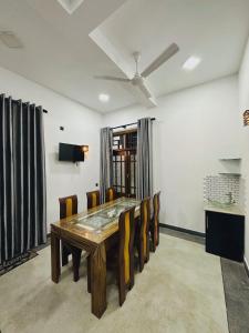 Un comedor con mesa y sillas de madera. en Villa 215, en Weligama