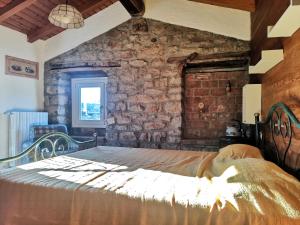 a bedroom with a bed in a stone wall at Ca del Vecchio in Ponte Nizza