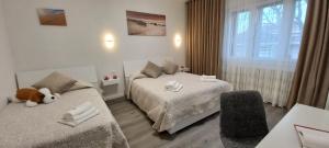a bedroom with two beds and a teddy bear sitting between them at Nadia&V in Marghera