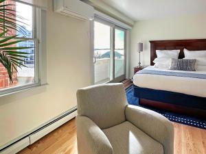 a bedroom with a bed and a chair and a window at Harborside Inn in Newport