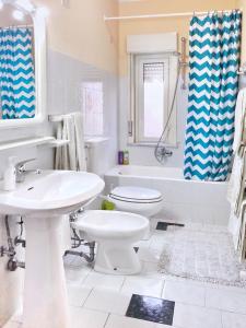 a white bathroom with a sink and a toilet at Tiziana in Giardini Naxos