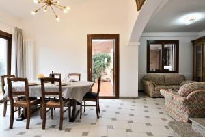 een eetkamer met een tafel en stoelen en een bank bij Amazing View - Exclusive Apartment Portu Frailis in Àrbatax