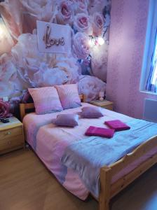 - une chambre avec un lit recouvert de roses dans l'établissement Chambres d'hôtes Natacha et Franck, à Labastide-Rouairoux