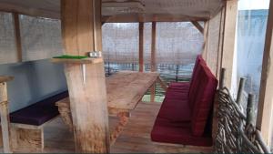 Zimmer mit einem Holztisch und einem roten Stuhl in der Unterkunft Дача, будинок,баня in Leplyavo