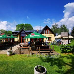 um restaurante com bancos e um guarda-chuva num parque em Penzion Kovářov em Frymburk