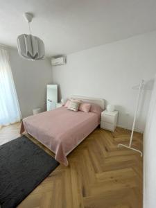 ein Schlafzimmer mit einem Bett mit rosa Kissen darauf in der Unterkunft Apartment Marina in Senj