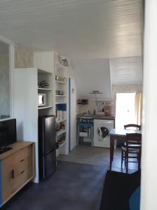 a kitchen with a refrigerator and a table in it at Logis côté Cour in Varennes-lès-Narcy