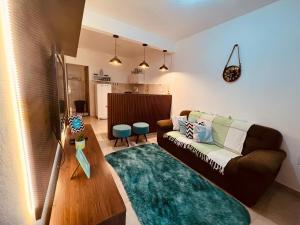 a living room with a brown couch and a green rug at Apto Aconchego da aldeia 02 ap08 in São Pedro da Aldeia +76 photos