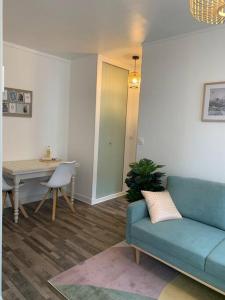 ein Wohnzimmer mit einem blauen Sofa und einem Tisch in der Unterkunft Le gîte entre val et rose in Provins