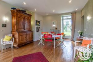 a dining room and living room with a table and chairs at Manoir d'Orbé in Montreuil-Bellay
