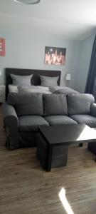 ein Wohnzimmer mit einem Sofa und einem Tisch in der Unterkunft Lieth-Hotel-Grünreich in Bad Fallingbostel
