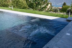 a swimming pool with blue water in a yard at Borgo Ermanno in Tignale