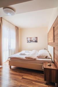 een slaapkamer met een bed en een groot raam bij APARTMÁN NELKA - VEĽKÁ LOMNICA in Veľká Lomnica