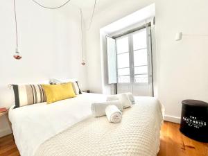 um quarto com uma grande cama branca e uma janela em Apartments Center Castelo de São Jorge em Lisboa