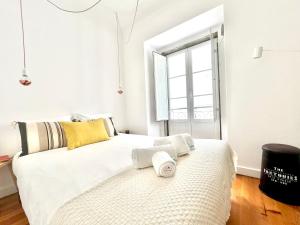 a bedroom with a large white bed and a window at Apartments Center Castelo de São Jorge in Lisbon