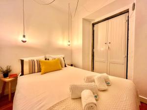 Un dormitorio con una gran cama blanca con toallas. en Apartments Center Castelo de São Jorge, en Lisboa