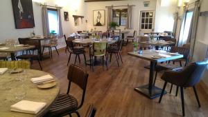 un restaurante con mesas y sillas en una habitación en The Great House Hotel, en Bridgend
