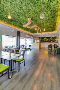 a restaurant with tables and chairs and a green ceiling at Natura Algarve Club in Albufeira