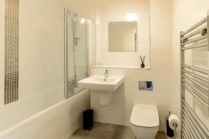 Baño blanco con aseo y lavamanos en The Hub by Pay As U Stay, en Milton Keynes