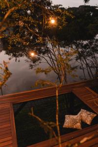 a reflection of a tree in a pond with lights at Arau Cabana Cheiro de Mato in Flores da Cunha