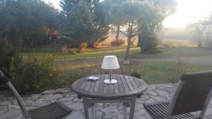 una mesa con una lámpara sentada en un patio en Chambre bohème avec balnéo en Idrac-Respailles