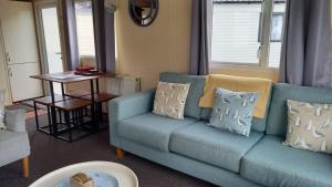 a living room with a blue couch and a table at Captain's Quarters in Brixham