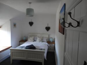 a bedroom with a bed and a window at Staddlestones Cottage in Bridport