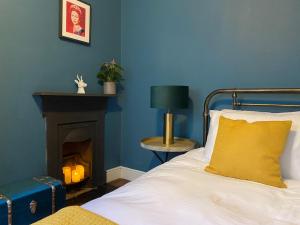a blue bedroom with a bed and a fireplace at Cosy Courtyard Apartment in Kemptown in Brighton & Hove
