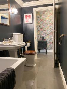 La salle de bains est pourvue de toilettes, d'un lavabo et d'une baignoire. dans l'établissement Cosy Courtyard Apartment in Kemptown, à Brighton et Hove