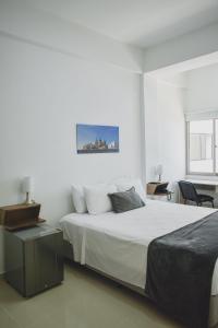 Dormitorio blanco con cama y mesa en Hotel El Marqués De Manga, en Cartagena de Indias