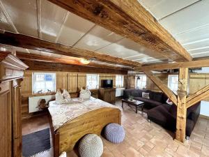 a bedroom with a large bed and a living room at Rustikales Studio-Apartment Blockstube im Haus Selma in Großschönau