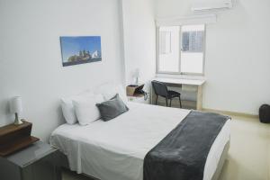 um quarto com uma cama, uma secretária e uma janela em Hotel El Marqués De Manga em Cartagena de Indias