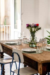 un tavolo in legno con sedie e un vaso di fiori di P'Ost ad Alba