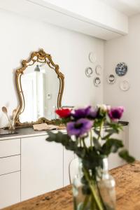 una cucina con specchio e tavolo con fiori viola di P'Ost ad Alba