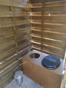 a toilet with a blue toilet seat in a wooden box at tente nature in Plouray