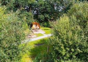 a cabin in the middle of a garden with trees at Paradise Lakeside Lodges in Wheldrake