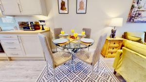 a dining room with a glass table and chairs at Chatham Serviced Apartments by Hosty Lets in Chatham