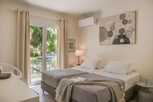 a bedroom with two beds and a large window at MARILIA VILLAS LASSI in Lassi +79 photos