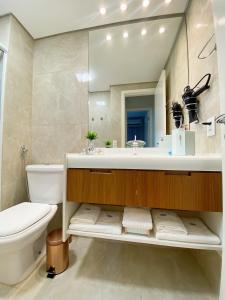 a bathroom with a sink and a toilet and a mirror at Sao Paulo Ibirapuera Privilege - Suite Deluxe in Sao Paulo