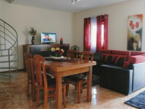 a living room with a table and chairs and a couch at Casa Quelhas in Besteiros