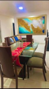 a dining room with a table and chairs and a painting at Casa Pandora in Ríohacha