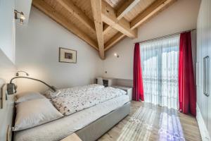 um quarto com uma cama e uma grande janela em Cesa Zapin 2 em Canazei