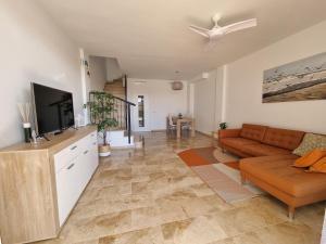 a living room with a couch and a flat screen tv at VILLA LORA Modern & New townhouse 2 Bedroom in Puerto de Santiago