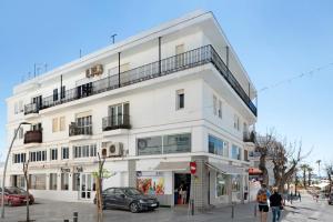 a white building with people walking in front of it at Apartamento Mercedes in Conil de la Frontera