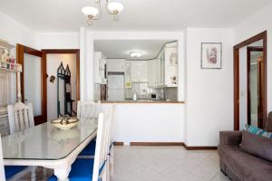 a dining room and kitchen with a table and a couch at Apartamento Mercedes in Conil de la Frontera