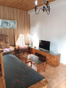sala de estar con TV, escritorio y sillas en Chalet Juana La Concha Valle de Agaete, en San Pedro