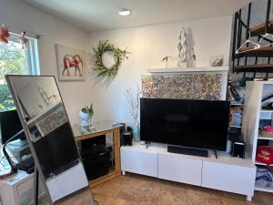 una sala de estar con una gran TV en un armario blanco en Del Mar townhouse by Torrey Pines Beach, en San Diego