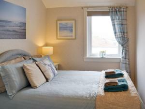 1 dormitorio con 1 cama con 2 toallas en Fernilea Cottage en Carbost