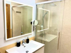 y baño con lavabo, ducha y espejo. en Adelfa - 2 hab, AA, parking gratis, junto Hospital en Murcia