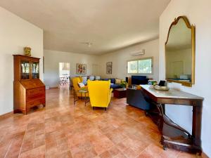 a living room with a table and yellow chairs at Villa BeaBella in Scicli